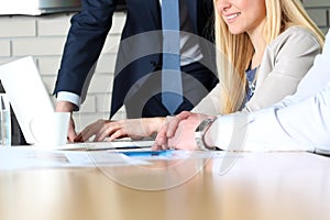 Business colleagues working together and analyzing financial figures on a laptop