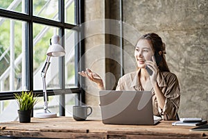 Business and communication concept, Asian woman working on laptop computer and reading smartphone on internet online at home, inde