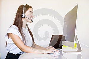 Business, communication, technology and call center concept - friendly female helpline operator with headphones and computer call