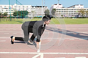 Business competition: businesswoman on start line and ready to reach the target