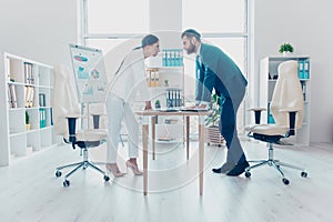 Business competition, full length side view profile of two colleagues in classic suits having disagreement and conflict, standing