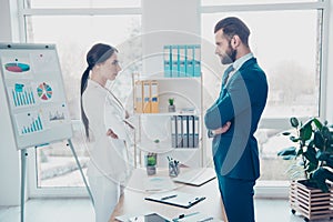 Business competition, side view profile of two colleagues in classic suits having disagreement and conflict, standing in