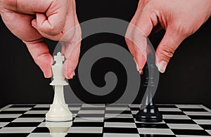 Business competition strategy and business success concept. Hand of two businessman moving for fighting dark king chess piece on
