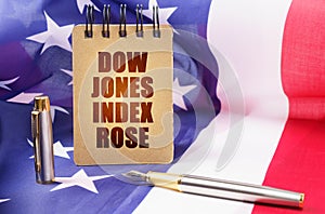 Against the background of the American flag is a notepad with the inscription - Dow Jones index rose