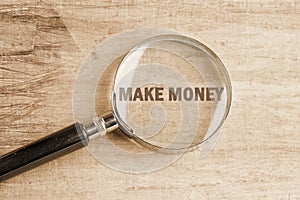 Business concept , business idea,business analysis. MAKE MONEY visible through a magnifying glass on an old faded background