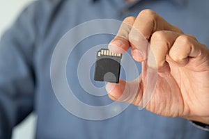 Business concept. Businessman holding SD card,memory card. Copy space