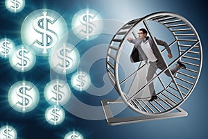 The business concept with businessman running on hamster wheel photo