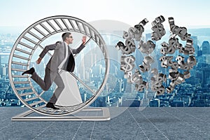 The business concept with businessman running on hamster wheel
