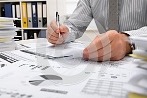 Business concept - businessman working in office, table and workspace close view, checks financial reports, writes and counts