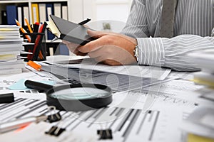 Business concept - businessman working with reports in office, table and workspace close view, analyzing financial data, writes