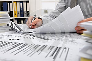 Business concept - businessman working with reports in office, table and workspace close view, analyzing financial data, writes