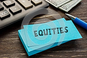 Business concept about EQUITIES with inscription on the sheet