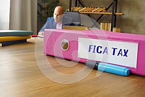 Business concept about FICA TAX Federal Insurance Contributions Act with phrase on the File Folder