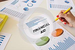Business concept about FINANCIAL AID with sign on the printout with diagrams and tables