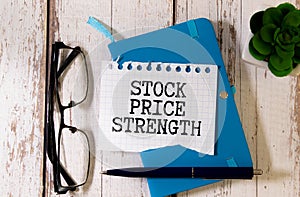 Business concept. On the financial charts lies a pen and a sign with the inscription - STOCK PRICE STRENGTH