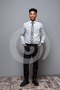 Business Concept - Full length portrait of confident african american businessman in the office.