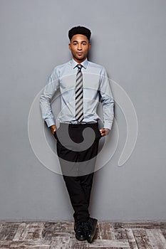 Business Concept - Full length portrait of confident african american businessman in the office.