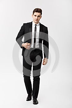 Business Concept: Full length portrait picture of a elegant business man in smart suit walking on white background.