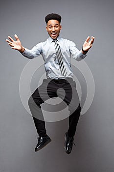 Business Concept - Full length portrait of successful african american businessman happy jumping in the office.