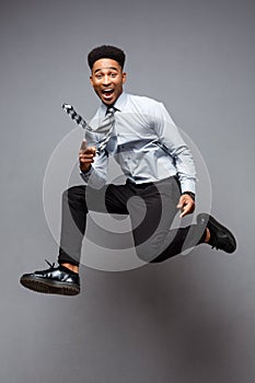 Business Concept - Full length portrait of successful african american businessman happy jumping in the office.