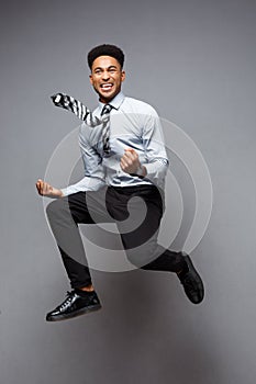 Business Concept - Full length portrait of successful african american businessman happy jumping in the office.