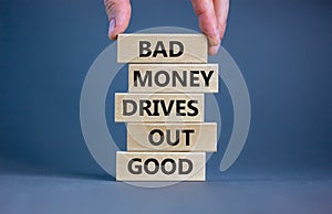 Business concept growth success process. Wood blocks on grey background, copy space. Businessman hand. Words `bad money drives ou