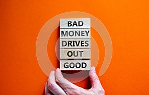 Business concept growth success process. Wood blocks on orange background, copy space. Businessman hand. Words `bad money drives