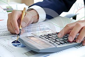 Business concept,Hand using calculator and hold pen pointing at