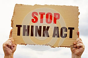 In the hands of a man is a cardboard sign with the inscription - Stop Think Act