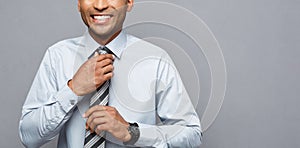 Business Concept - Happy confident professional african american businessman posing over grey background.