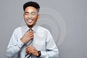 Business Concept - Happy confident professional african american businessman posing over grey background.