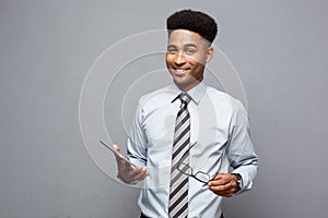Business Concept - Happy handsome professional african american businessman holding digital tablet and talk with client.