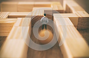 Business concept Image of challenge. A man stands in the maze looking for the exit and unaware of the danger approaching him