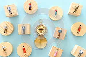 Business concept image of group of miniature people and compass. Metaphor of society structure and social issues