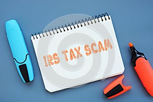 Business concept about IRS TAX SCAM with inscription on the sheet