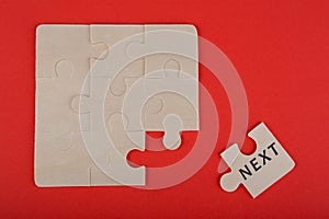 Jigsaw Puzzle Pieces with word & x22;Next& x22; on red background