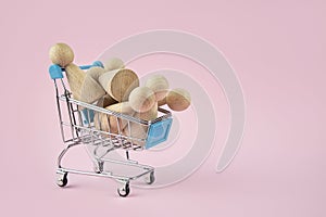 Business concept. Lamp with wooden people in a shopping cart on a pink background. Employment, selection of people. Business ideas