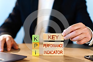 Business concept. a man is building wooden blocks with the words KEY, Performance, Indicator.