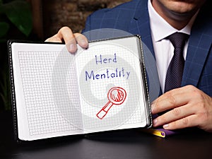 Business concept meaning Herd Mentality with inscription on blank notepad photo