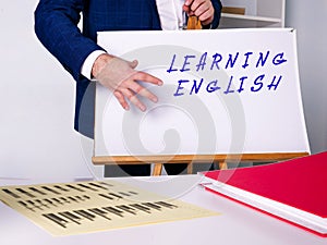 Business concept meaning LEARNING ENGLISH with inscription on the sheet