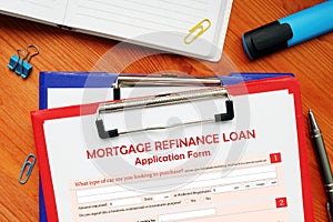 Business concept meaning MORTGAGE REFINANCE LOAN Application Form with sign on business paper in hand