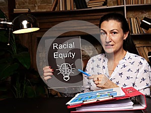 Business concept meaning Racial Equity with sign on blank card in hand