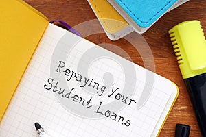Business concept meaning Repaying Your Student Loans with sign on the page
