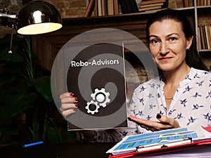 Business concept meaning Robo-Advisors with phrase on blank notepad in hand photo