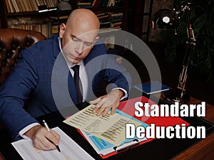 Business concept meaning Standard Deduction Businessman, executive manager hand filling paper business document
