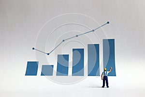 Business concept with a miniature person with a graph.