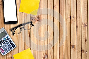 Business concept mobile and calculator and eyeglasses on wooden plank