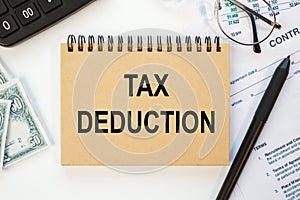 Business concept - notebook writing TAX DEDUCTION