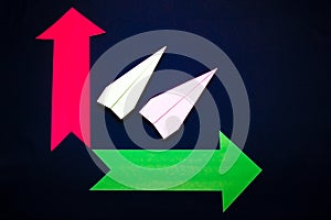 Business concept with paper plane and colored arrows on dark blue background