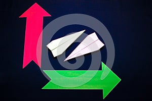 Business concept with paper plane and colored arrows on dark blue background